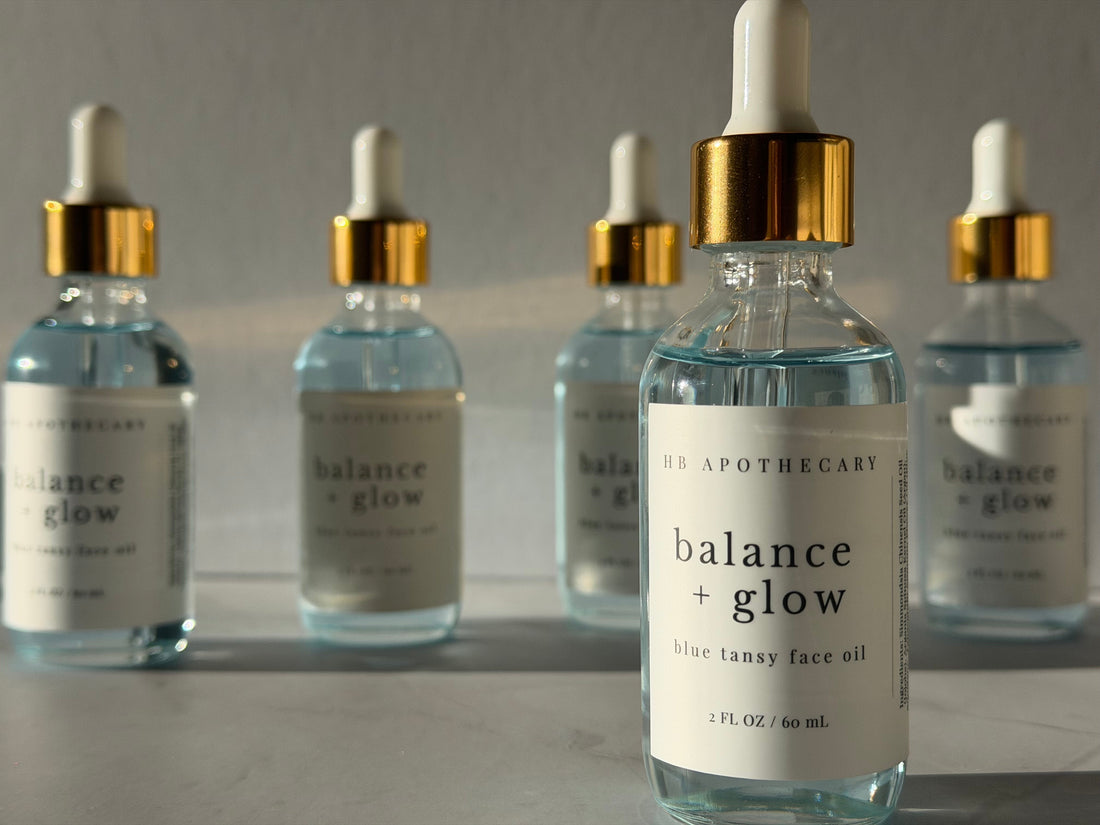 Light blue oil in clear glass bottle with cold and white cap, white label black writing